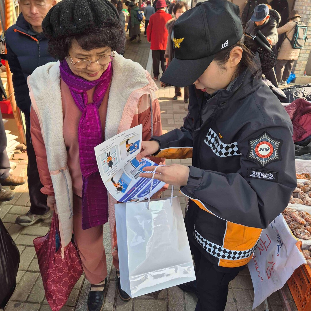 춘천소방서 소방관이 춘천 풍물시장 일원에서 설 명절 대비 화재예방 캠페인을 진행하고 있다.
