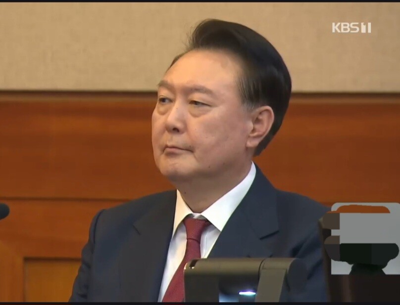 윤석열(피청구인 자격) 대통령이 지난 23일 오후 서울 종로구 헌법재판소에서 열린 탄핵심판 4차 변론기일에 출석, 침통한 표정으로 앉아 있다. 윤 대통령은 이날 변론에서 포고령과 관련, “김용현 전 국방장관이 작성한 포고령이 법적으로 검토해야 할 부분이 있었지만, ‘계엄 자체가 집행 가능성이 없었기 때문에’ 상징적인 측면에서 이걸 그냥 놔두자고 했다”라는 진술을 했다. kbs 뉴스속보 화면 캡처