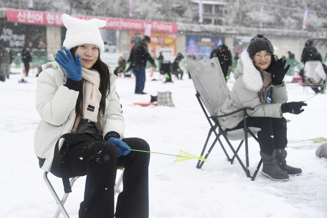 눈을 맞으며 산천어 얼음낚시 삼매경에 빠져있는 관광객