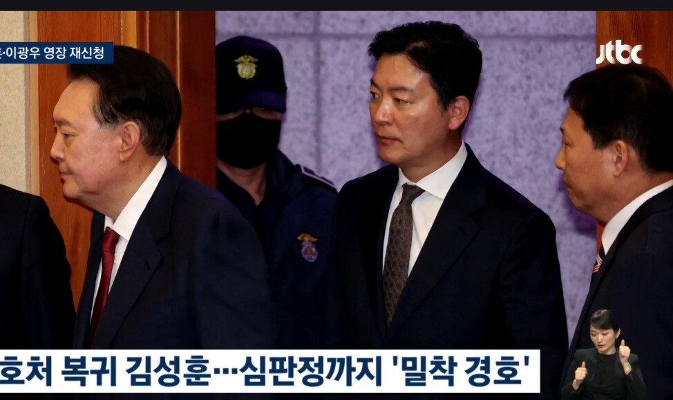 검찰의 구속영장 반려로 석방된 특수공무집행방해 피의자인 김성훈(가운데) 대통령실 경호차장이 지난 23일 헌재 탄핵심판 4차 변론기일에 직접 출석한 윤석열 대통령을 밀착경호하며 대심판정으로 들어서고 있다.