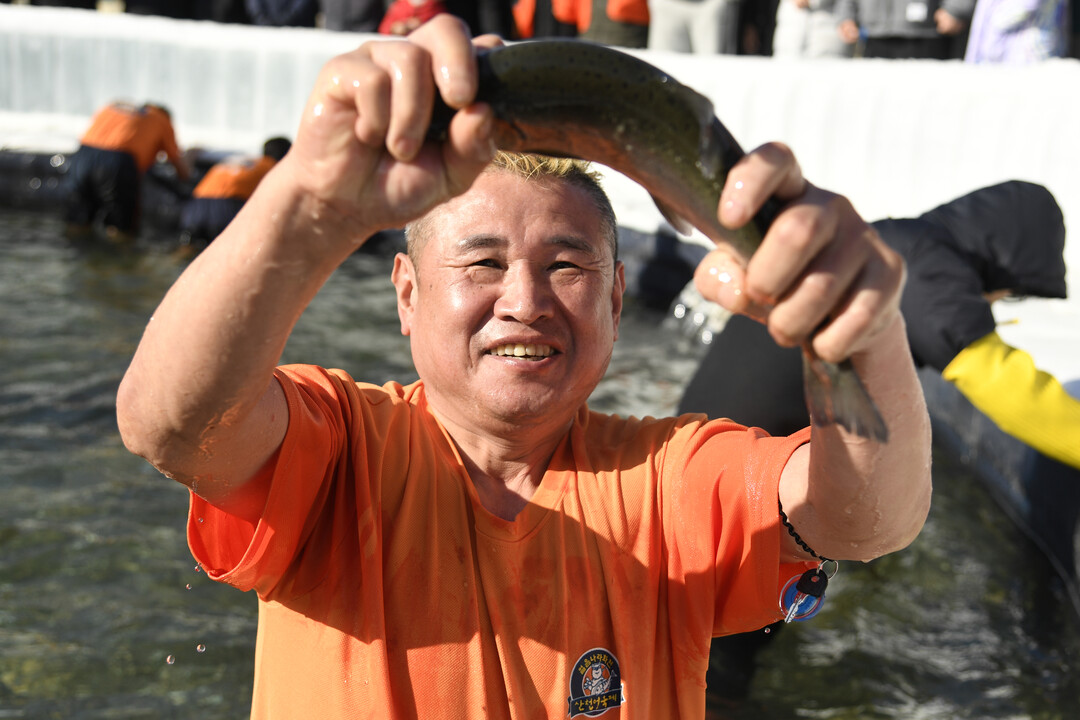 산천어 맨손잡기를 즐기는 관광객