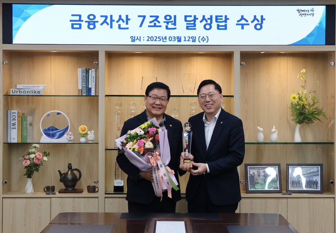 맹석인 서울본부장(사진 오른쪽)이 백호 조합장(사진 왼쪽)에게 금융자산 7조원 달성탑 트로피를 전달하고 있다. 농협 제공