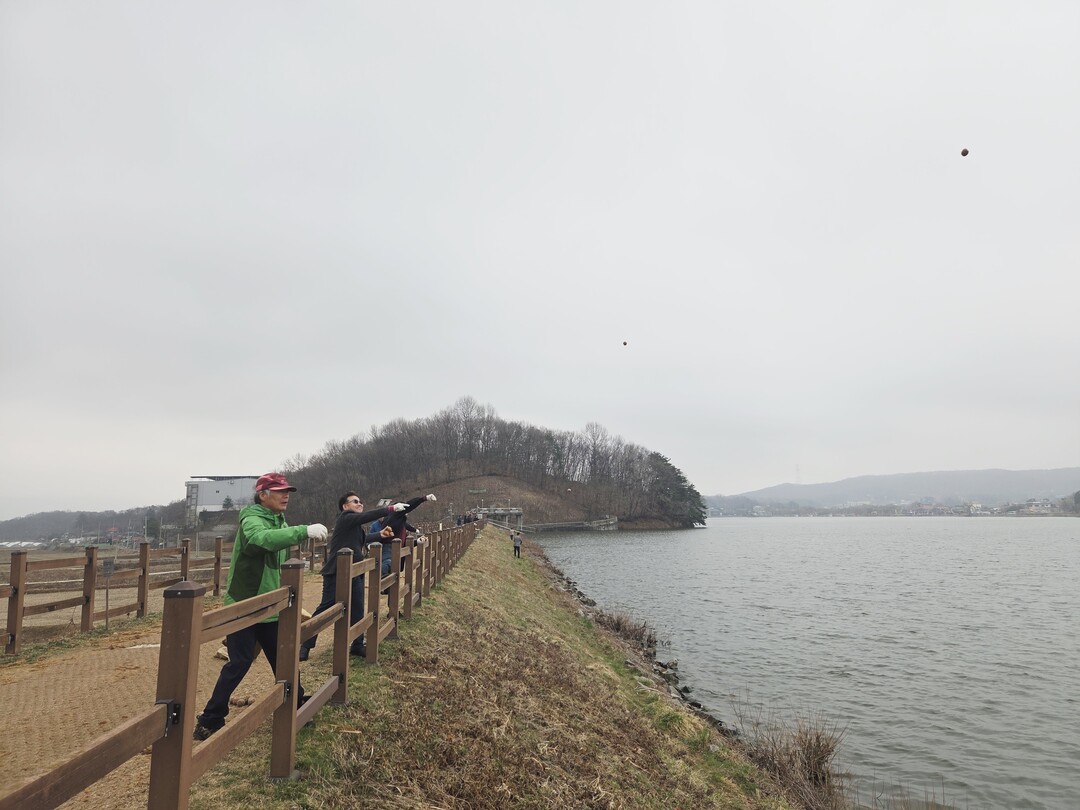 용인특례시 대표 농업인 단체 농촌지도자용인시연합회원들은 용담호수 수질정화를 위해 EM흙공 500개를 던졌다.용인시 제공