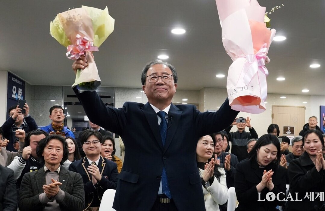 부산시교육감 재선거에 출마한 김석준 후보가 3일 0시 직후 부산진구 서면로터리 인근에 위치한 선거사무실에서 당선이 확정되자 지지자로부터 꽃다발을 받아들고 환호하고 있다. 선거캠프 직원과 지지자들이 박수를 치고 있다. 김석준 당선인 사무실 제공