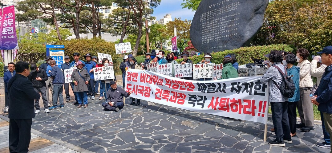 부산 남구 뉴스테이 감만1구역재개발조합 현 집행부와 조합원 60여명이 21일 오전 남구청사 정문에서 국토교통부·부산시·남구청의 합동점검(감사 및 실태조사)에 항의하는 집회를 개최하고 있다. 오는 26일(토) 열리는 정기총회 때 조합장 후보로 출마한 직전 조합장 김경래씨(왼쪽)가 “뉴스테이 집행부에 대한 합동감사에 앞서 악성민원 3,000건 제기한 감만비대위측 위원장 안진현과 조합원, 관련자들에 대해 업무방해 혐의로 고발부터 먼저하라”라고 일갈하고 있다. 김 직전 조합장은 마이크도 없는 상태에서 장비처럼 우뢰와 같은 목청으로 지난 4~5년 동안 위불법 행위를 일삼아온 비대위의 행태를 지적했다. 그는