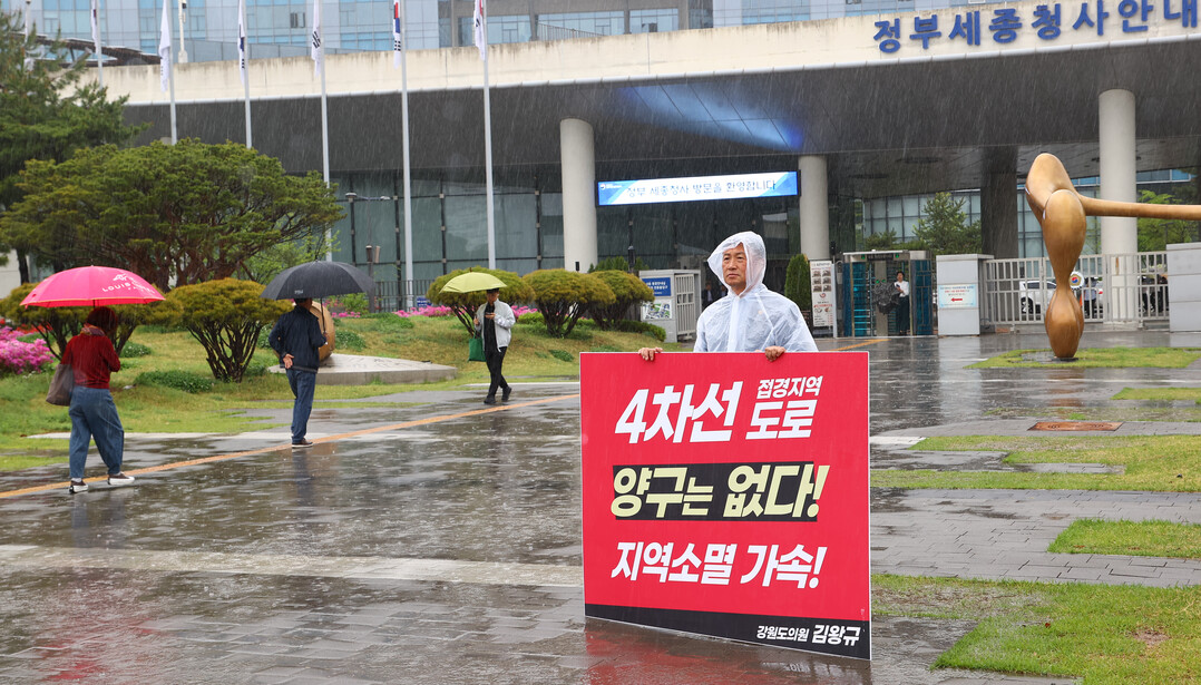 빗속에서 1인 시위를 하고 있는 김왕규 의원