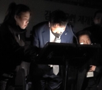 부산 남구 감만1구역재개발조합 선관위가 지난 26일 오후 2시 옛 부산외대 운동장에서 ‘2025년도 정기총회’를 개최해 선거관리위원회 구성, 올해 조합운영비 예산안 승인, 임원(조합장·감사·이사) 선임 등 7개의 안건을 통과시켰다. 이날 밤 9시 30분경 사회를 맡은 변호사가 선관위가 건네준 투표 결과가 담긴 메모지를 휴대폰 라이터 불빛에 의지한 채 발표하고 있다.