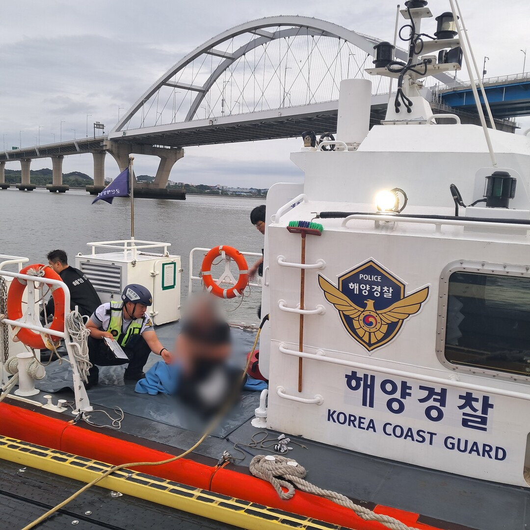 구조된 A씨를 인근 항포구에 대기중인 119구급대에 인계하고 있다. 군산해경 제공