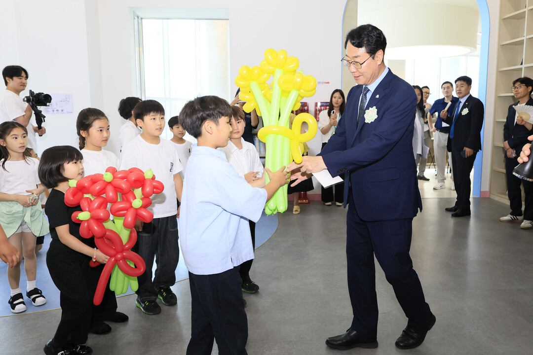 화성특례시 가족만세센터 개관을 축하하며 어린이들이 정명근 시장에게 풍선으로 만든 꽃다발을 전달하고 있다.