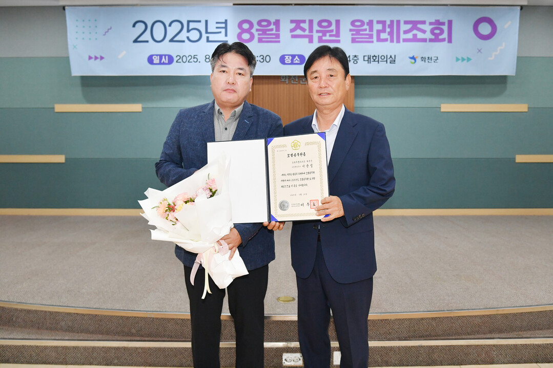 최문순 군수(오른쪽)가 화천군청 8월 직원 월례조회에서 모범공무원증을 수여했다.