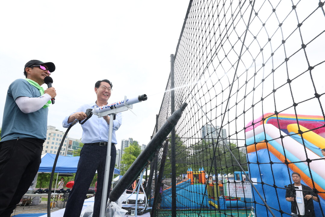 정명근 화성특례시장이 새솔동 수노을 물놀이 축제에서 시원한 물줄기를 뿌리고 있다