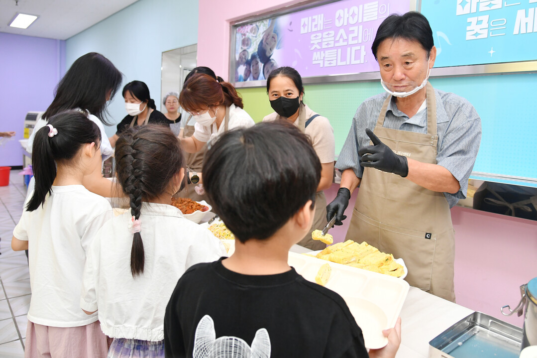 최문순 화천군수가 여름방학 돌봄교실 어린이들에게 급식봉사를 하고 있다