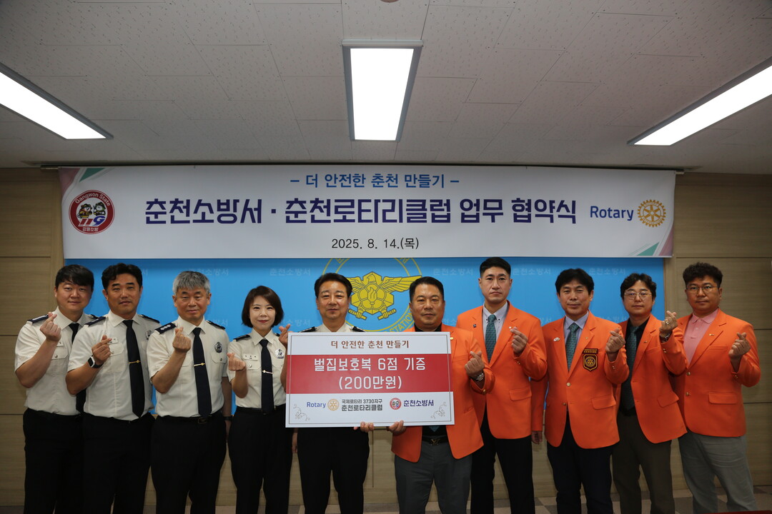 ‘춘천소방서 & 춘천로타리클럽 업무협약 및 기증식’에 참석한 소방관 및 회원들이 기념촬영을 하고 있다