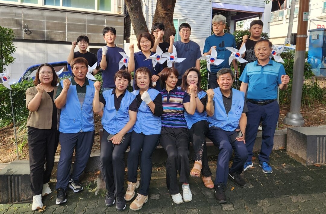 부산 북구 구포3동 행정복지센터와 구포3동 청소년지도협의회 회원들이 공동으로 지난 13일 관내 포천사거리 쌈지공원에서 ‘나라사랑 태극기 달기 운동’을 전개한 뒤 기념촬영을 하며 파이팅을 외치고 있다. 북구청 제공