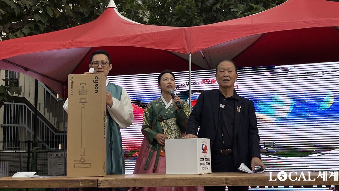이번행사의 추진위원장이 추첨을 하고 있다.今回の行事の推進委員長が抽選回をしている。