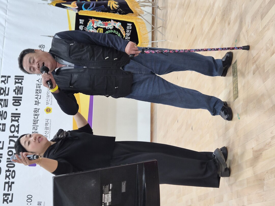 제23회 전국장애인가요제에 출연한 한 50대 장애인이 지팡이에 몸을 의지한 채 열창을 하고 있다. 진행자가 돕고 있다. 