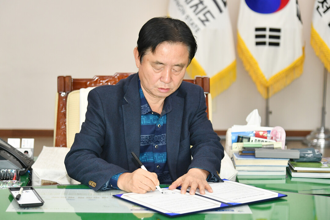 최문순 군수가 화천군과 한국수자원공사 평화의댐 지사 댐 주변지역 공부방 지원협약서에 서명을 하고 있다