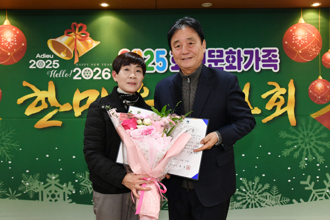 최문순 군수가 2025 화천 문화가족 한마음 연찬회에서 군민에게 표창장 전수 후 기념촬영을 하고 있다