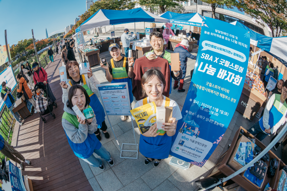 SBA &times; 굿윌스토어 동행기업 나눔 바자회에서 SBA 임직원 자원봉사단이 판매되고 있는 기증물품을 들고 환히 웃고 있다. SBA 제공