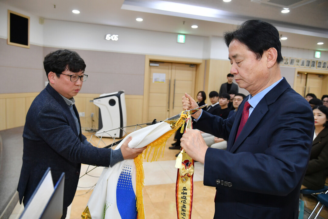 대통령단체표창 휘장을 군기에 묶고 있는 최문순 군수