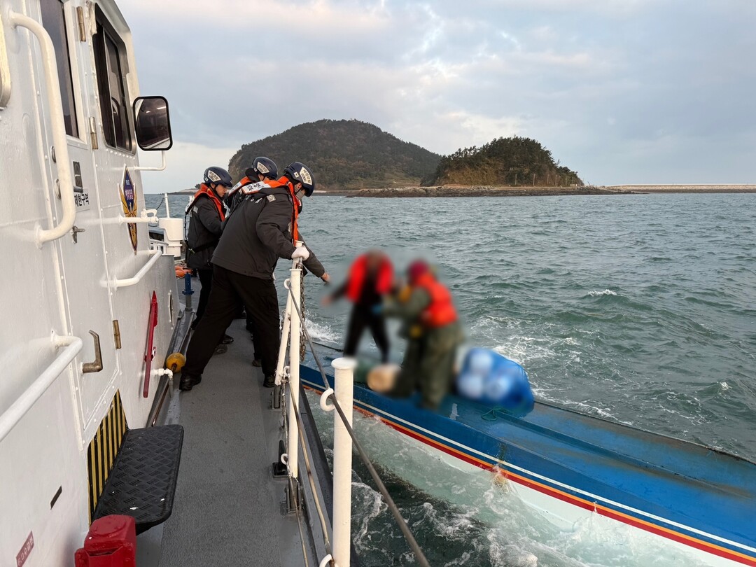 해경이 전복된 어선에서 선원들을 구조하고 있다. 군산해경 제공