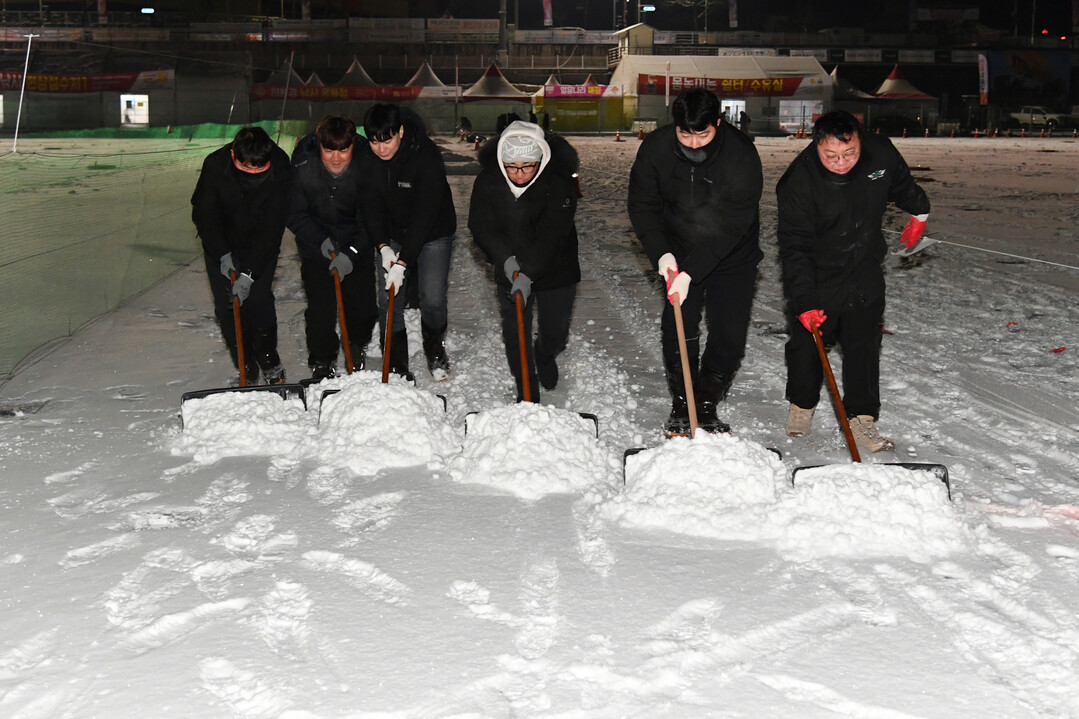 11일 화천산천어축제장에서 전날 밤 내린 폭설을 공무원을 비롯한 축제 관계자와 종사자 등이 관광객 안전을 위한 제설작업을 하고 있다.