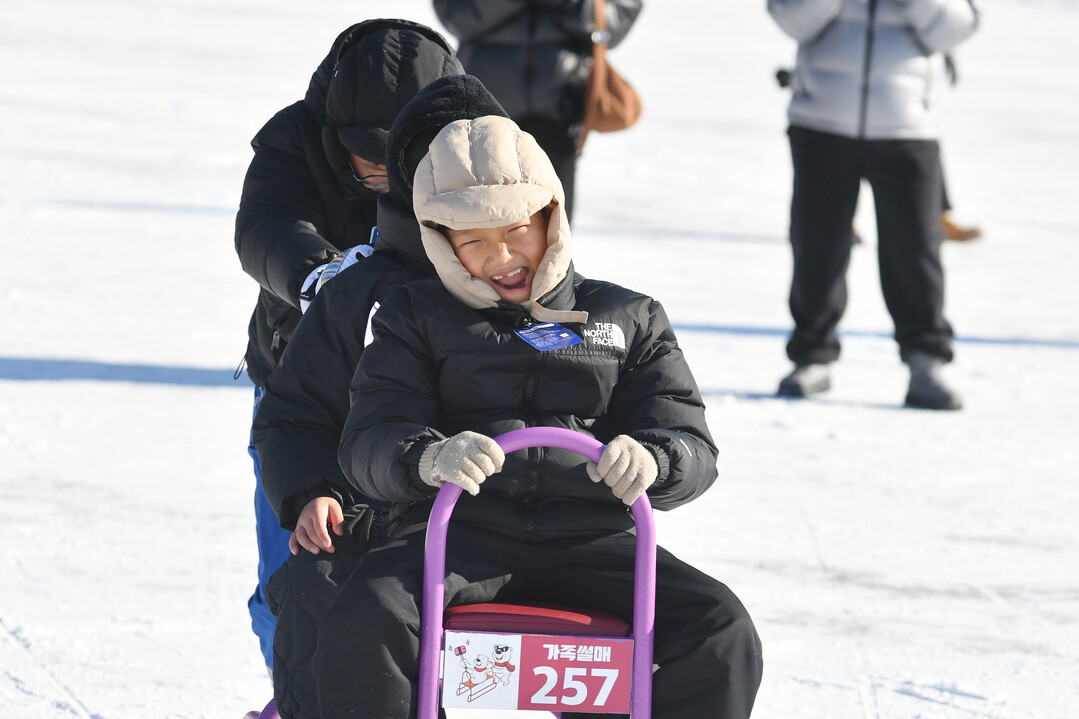 가족 단위 관광객들이 얼음썰매 체험을 즐기며 축제를 만끽하고 있다