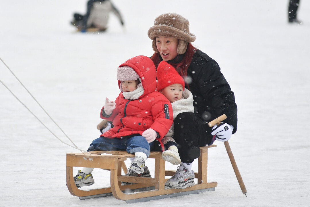 2026 화천산천어축제 개막 사흘째인 12일, 함박눈이 내리는 가운데 관광객들이 얼음썰매 체험을 즐기고 있다. 

