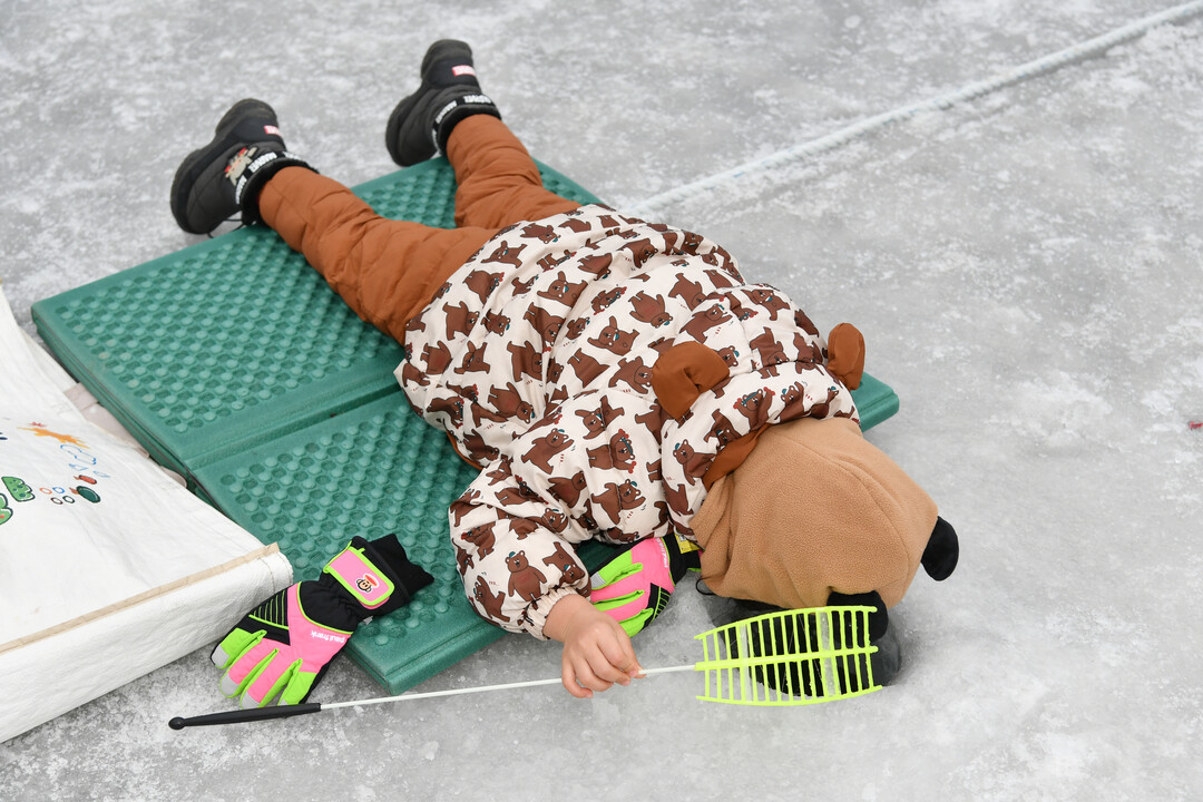 18일, 주말을 맞아 이른 오전부터 화천산천어축제장을 찾은 어린이가 산천어를 잡고 있다. 