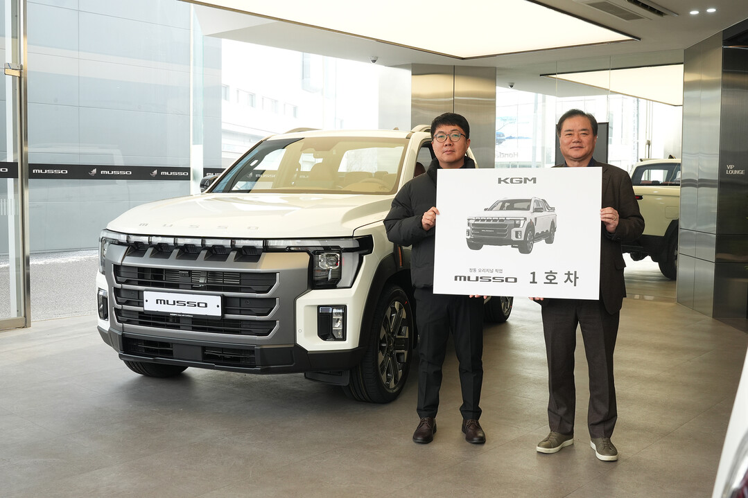 지난 19일 KGM 익스피리언스 센터 일산에서 열린 &lsquo;무쏘 1호차 전달식&rsquo;에서 1호차 주인공 이미남 대표(왼쪽)와 권교원 사업부문장(오른쪽)이 기념 촬영을 하고 있다. KGM 제공
