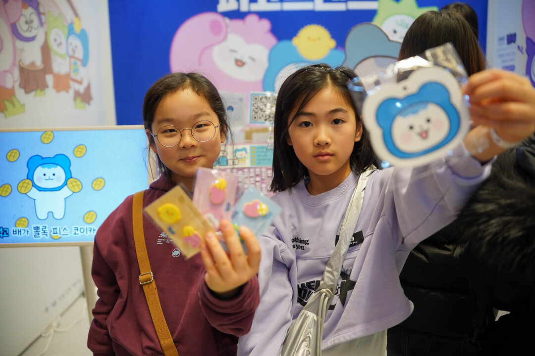 29일 서울 강남구 코엑스에서 열린 &lsquo;K-일러스트레이션페어 서울 2026&rsquo; 코이카 피코프렌즈(PeKO Friends) 부스를 방문한 관람객이 이벤트 선물을 받고 즐거워하고 있다.&nbsp;