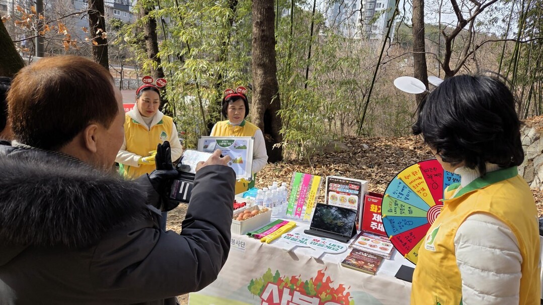 신천지자원봉사단 부산경남동부지역연합회 회원들이 최근 부산 해운대 대천공원서 진행한 산불예방캠페인에서 시민들에게 사진전을 통해 산불 예방의 중요성에 알리고 있다. 이하 신천지자원봉사단 부산경남동부지역연합회 제공