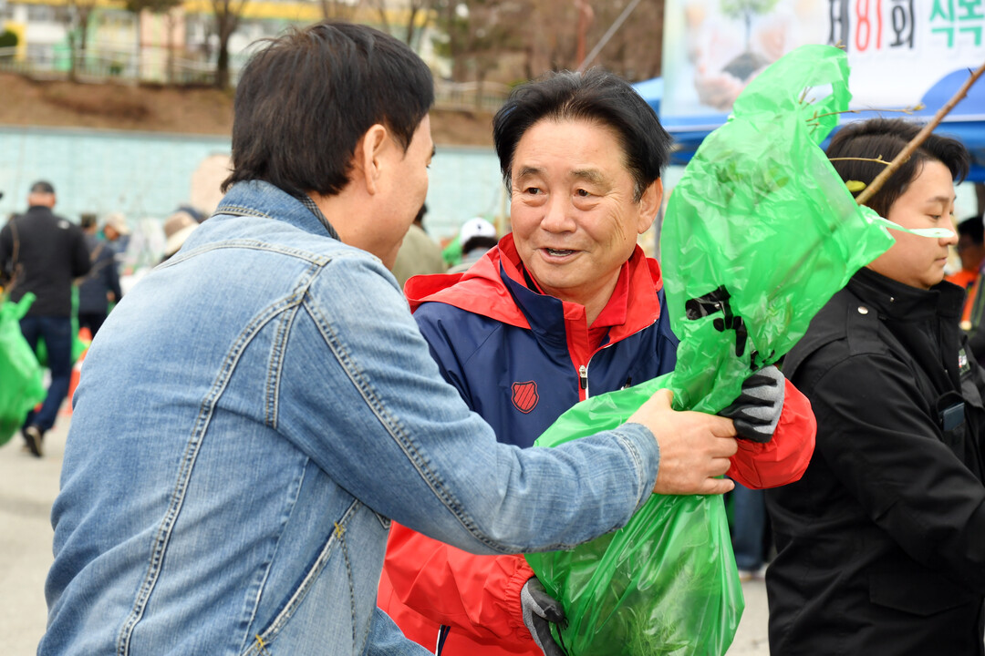 최문순 군수(오른쪽)가 &lsquo;나무 나눠주기 행사&rsquo;에 참여한 주민에게 나무를 전달하고 있다(화천군청 제공)