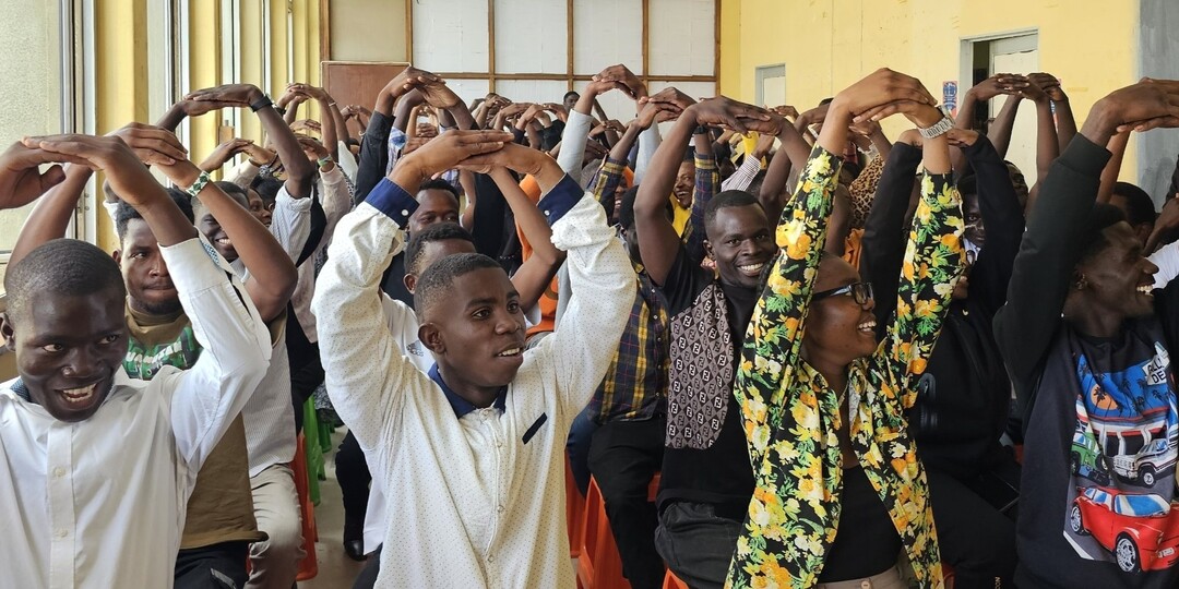 신천지예수교회 바돌로매 아프리카 잠비아 루사카지역센터에서 수강생들이 O/X 퀴즈 수업에서 머리 위로 두 팔을 모아 &lsquo;O&rsquo; 자를 만들며 활짝 웃고 있다.