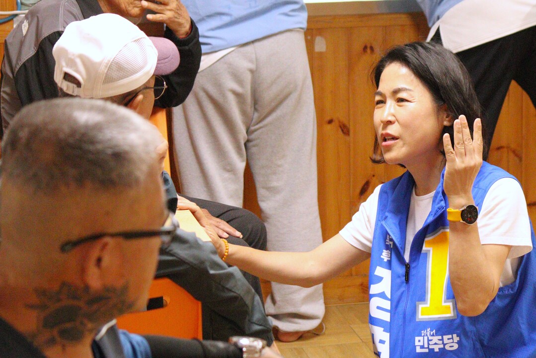 정명희 북구청장 당선인은 그리에서 주민들과 키를 마추어 대화를 하고 있다.인수위원회 제공
