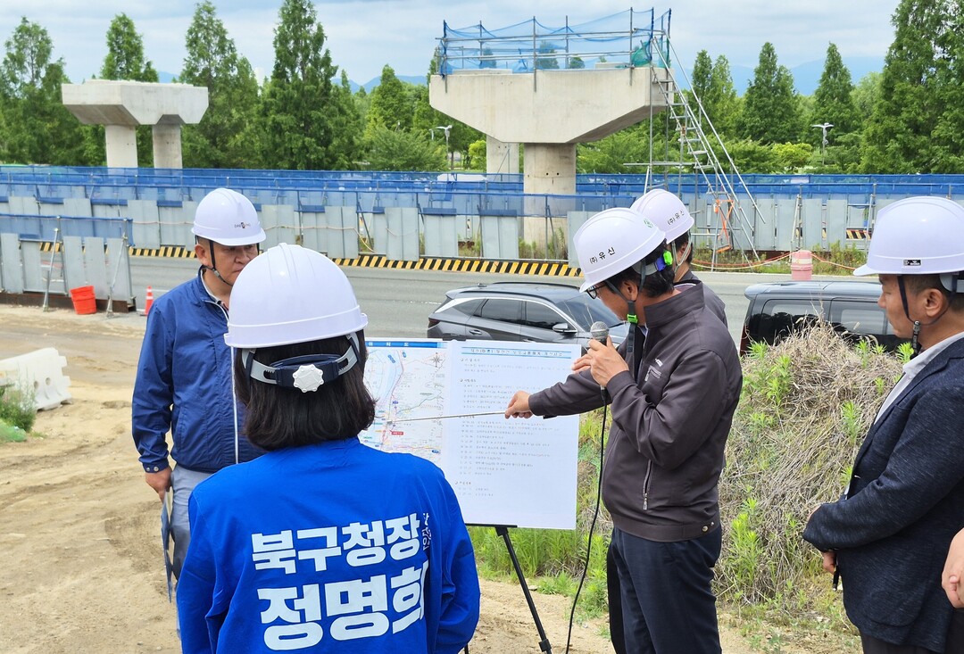 정명희 부산 북구청장 당선인이 25일 북구 화명동 금곡과선교 회전교차로 공사현장에서 부산시 등으로부터 설명을 듣고 있다.