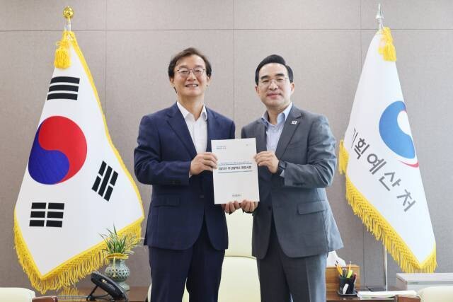 전재수 부산시장(왼쪽)이 22일 정부세종청사에서 박홍근 기획예산처 장관을 예방, 2027년 부산시 주요 현안사업예산이 기재된 자료집을 전달한 뒤 기념촬영을 하고 있다. 부산시 제공