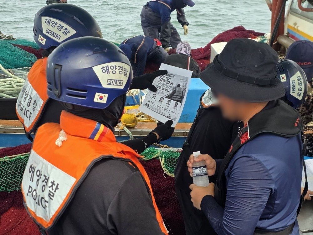 군산해경이 어선원 대상 생수를 배부하며 구명조끼 착용 계도를 하고있다. 군산해경 제공