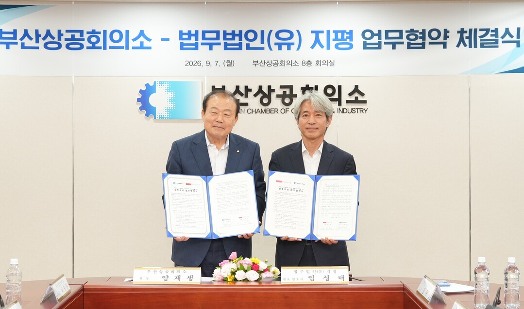 부산상공회의소 양재생(사진 왼쪽) 법무법인(유) 지평 대표변호사가 7일 부산상의 8층 회의실에서 &lsquo;부산지역 기업 발전 및 상호 협력체계 구축을 위한 업무협약&rsquo;에서 각자 서명한 협약서를 든 채 기념촬영을 하고 있다.&nbsp; 이하 부산상의 제공