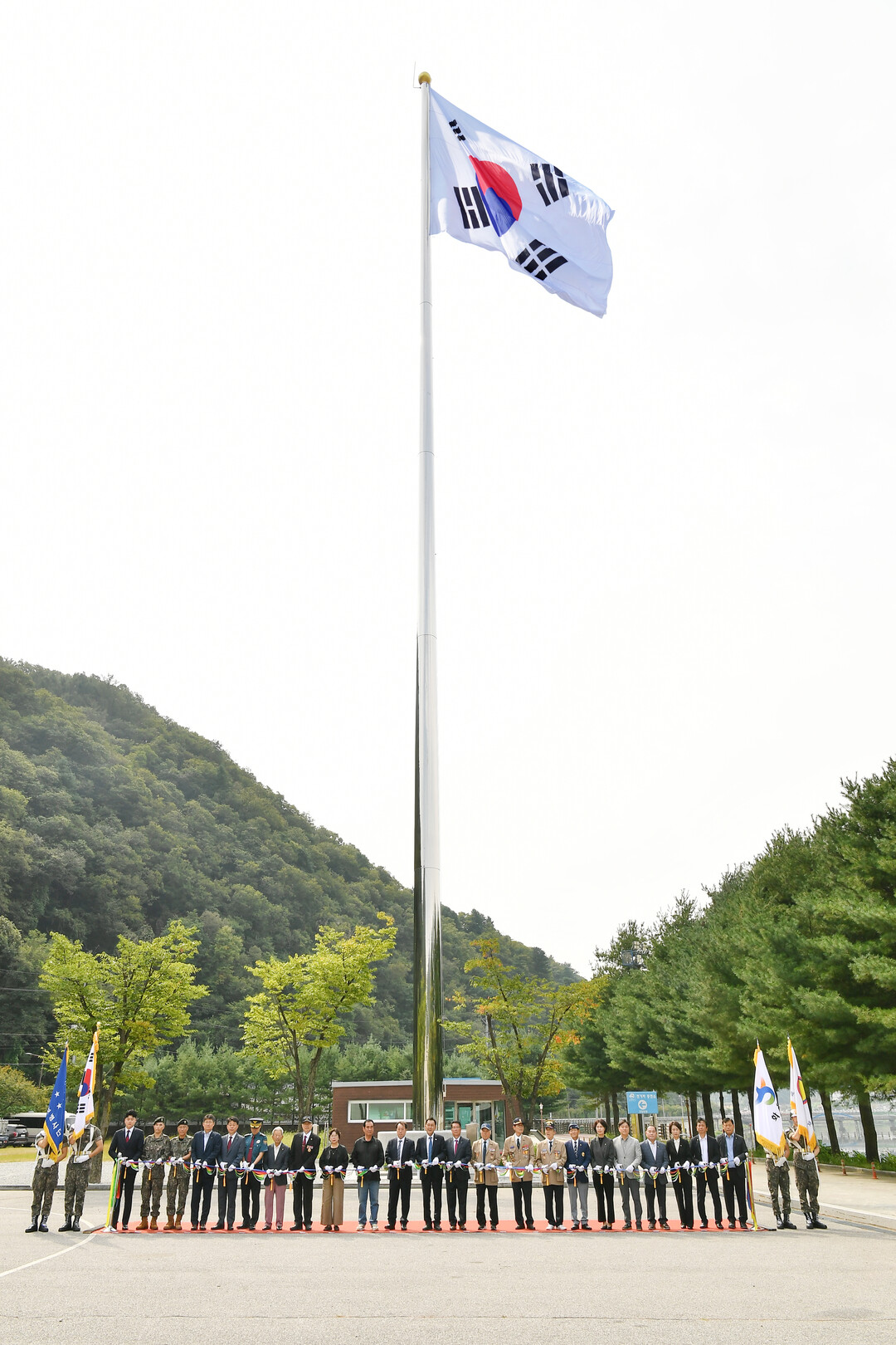 화천군 청소년수련관 대형 태극기 게양대 준공식에 참석한 내빈들이 테이프 커팅을 하고 있다(화천군청 제공)