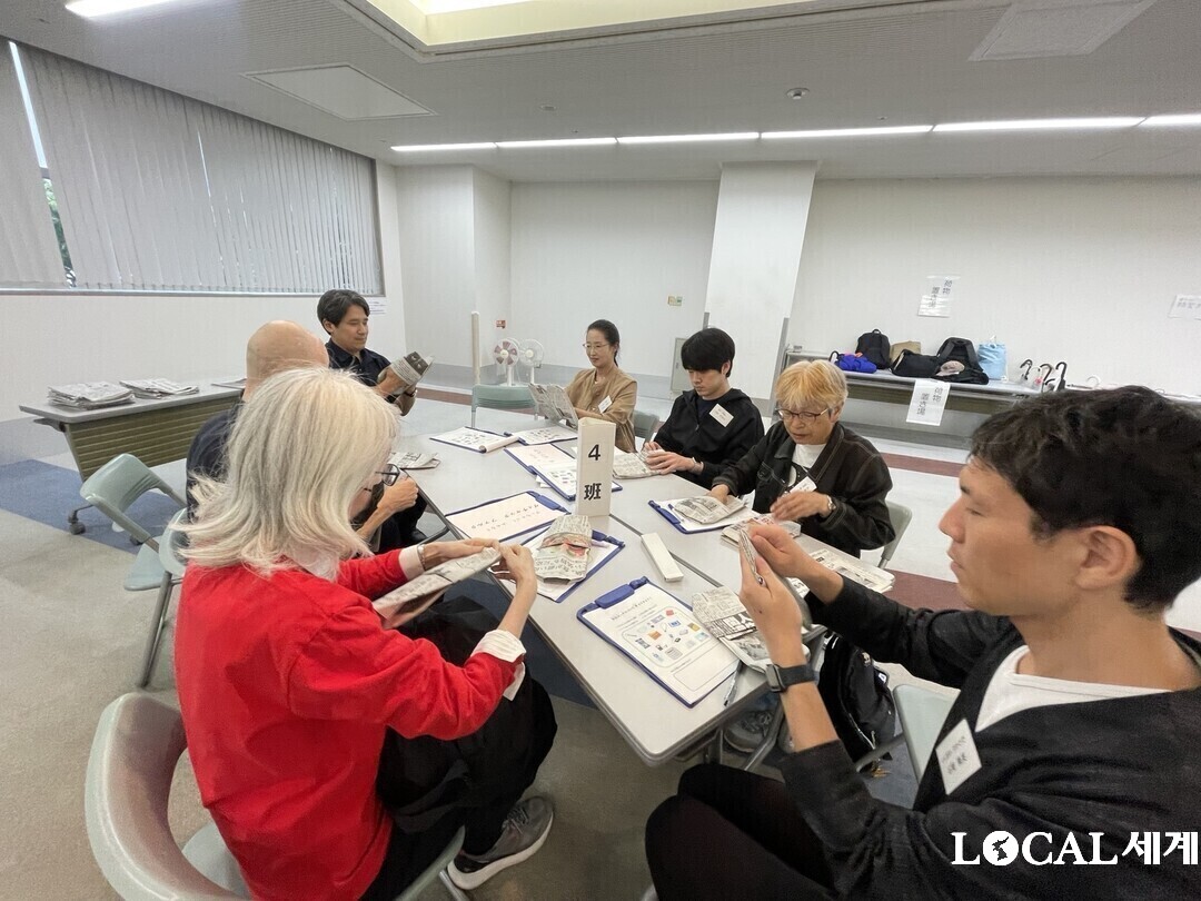 참가자들이 신문지를 활용한 간이 슬리퍼 만들기 체험을 하고 있다. 사진 여가옥 기자