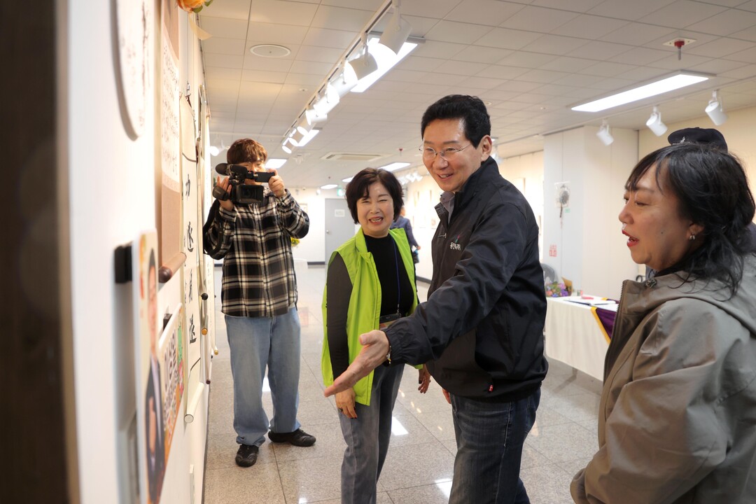 이상일 용인특례시장이 18일 수지구 상현2동 &lsquo;제6회 소실봉 문화축제&rsquo;에서 상현갤러리 수강생의 작품을 살펴보고 있다.