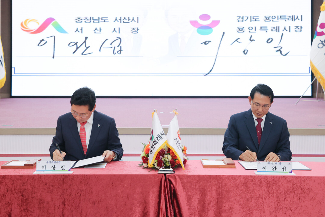  이상일 용인특례시장(왼쪽)과 이완섭 서산시장(오른쪽)이 자매결연 협약서에 서명하고 있다. 용인시 제공
